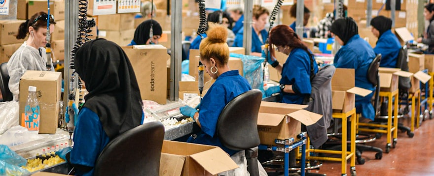 A crew in work uniform along a production line